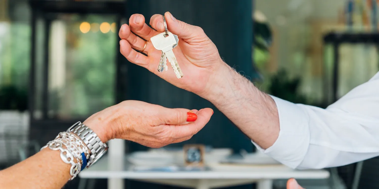 Keys being handed over in the doorway of a rented home