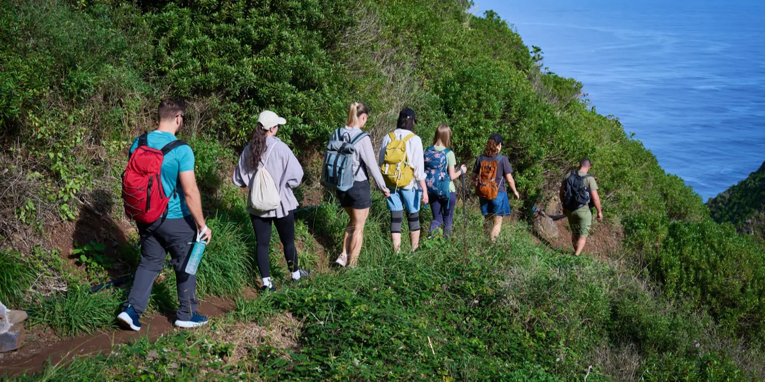 A small tour group setting out along a mountain trail