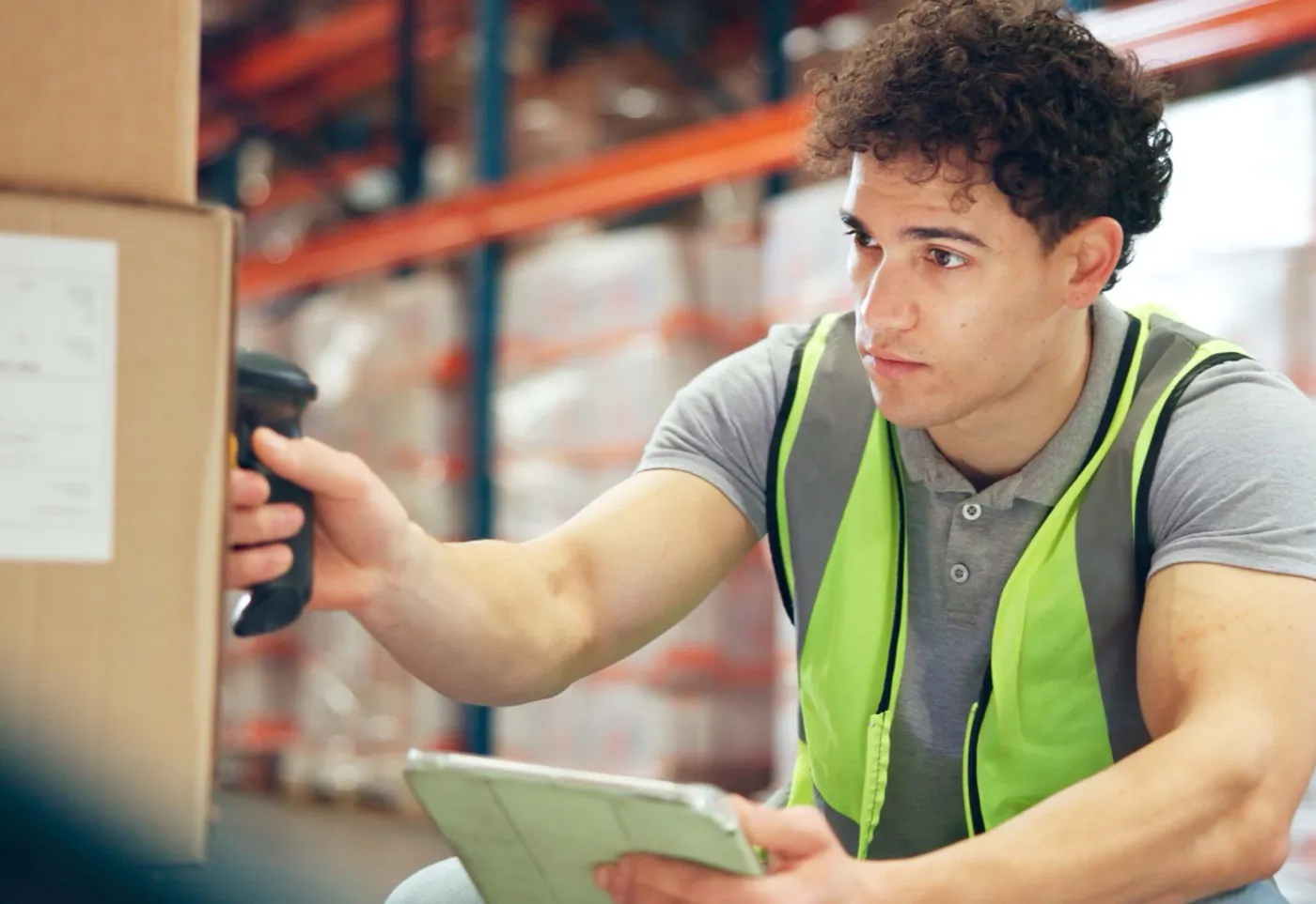 A warehouse operator scanning cartons on a loading dock